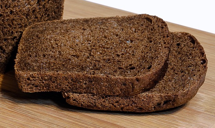 two rye flour slices of bread on breadboard